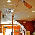 Brewmaster belt-driven ceiling fan, antique brass finish, with wooden cherry finish blades, in a bar